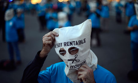 Masked employees from the Telefonica phone company protest in Barcelona, Spain